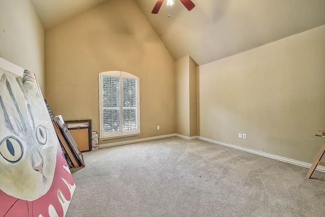 interior space featuring high vaulted ceiling, light colored carpet, baseboards, and a ceiling fan