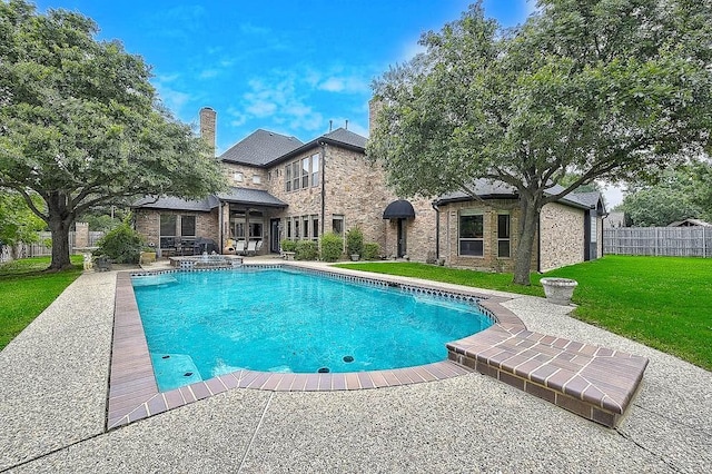 view of swimming pool featuring a patio area, a pool with connected hot tub, fence, and a lawn