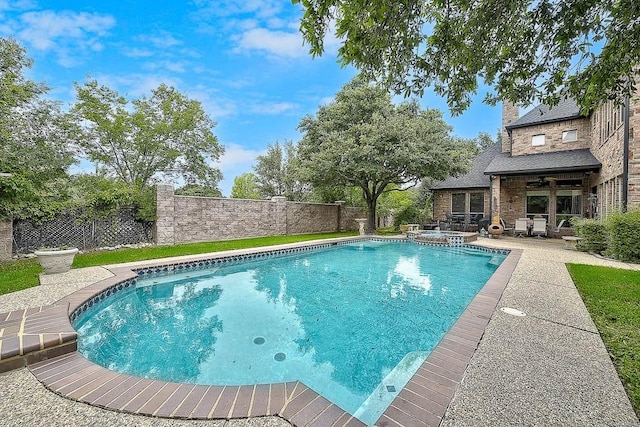 view of pool featuring a ceiling fan, a patio area, a fenced backyard, and a pool with connected hot tub