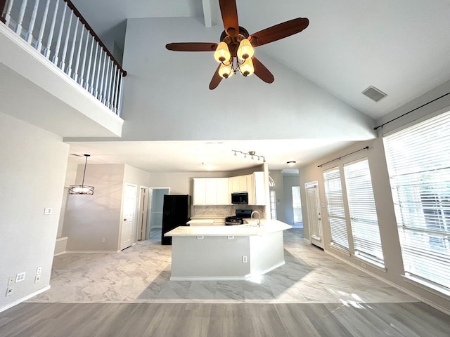 kitchen featuring sink, white cabinetry, high vaulted ceiling, kitchen peninsula, and black appliances