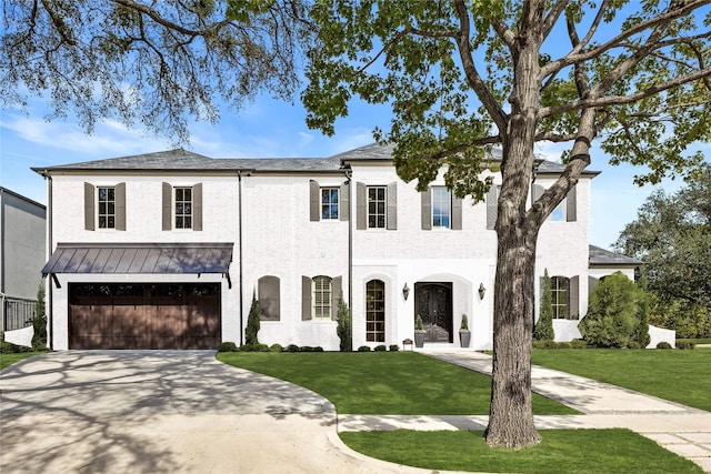 view of front facade featuring brick siding, an attached garage, a standing seam roof, driveway, and a front lawn