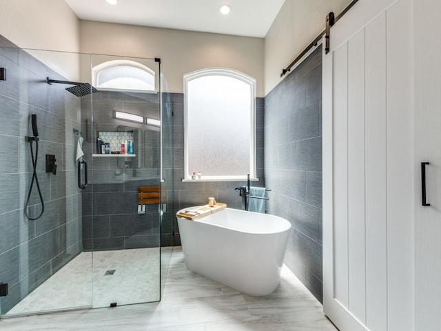 bathroom with shower with separate bathtub and tile walls