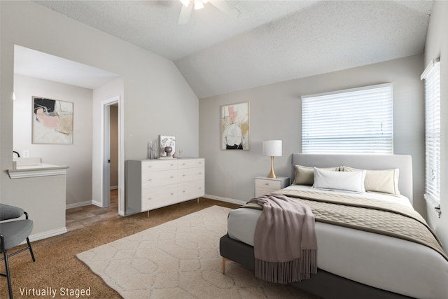 bedroom with carpet, vaulted ceiling, a textured ceiling, and ceiling fan