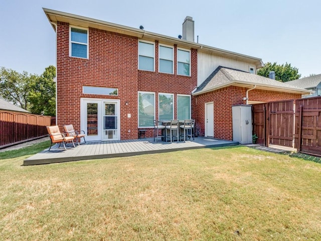 rear view of property with a yard and a wooden deck