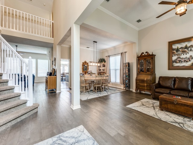 living room with crown molding, plenty of natural light, and dark hardwood / wood-style flooring