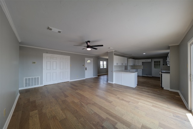 unfurnished living room featuring ceiling fan, crown molding, and light wood-type flooring