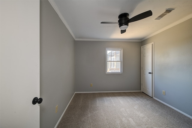 carpeted spare room with ceiling fan and ornamental molding