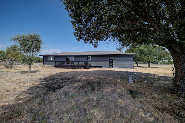 rear view of house featuring a wooden deck