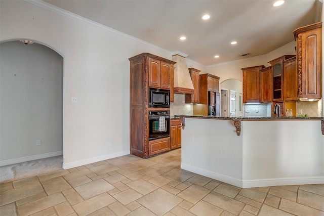 kitchen with custom range hood, dark stone countertops, tasteful backsplash, black appliances, and crown molding