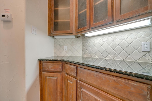 kitchen with dark stone countertops and decorative backsplash