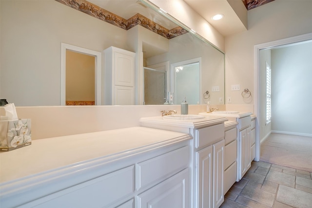 bathroom featuring a shower with shower door and vanity