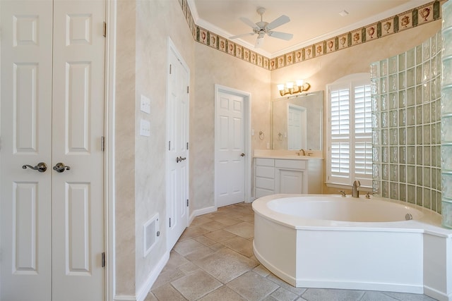 bathroom with ornamental molding, ceiling fan, a washtub, and vanity