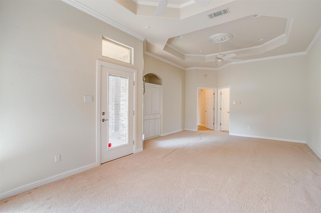 unfurnished bedroom featuring ornamental molding, a raised ceiling, and light carpet