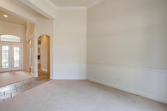 unfurnished room with crown molding, light carpet, and french doors