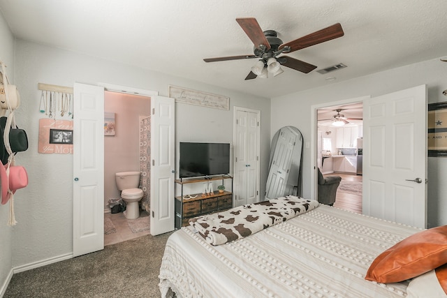 bedroom with a closet, dark colored carpet, connected bathroom, and ceiling fan