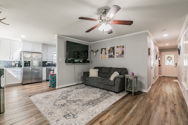 living room featuring ceiling fan, crown molding, and light hardwood / wood-style floors