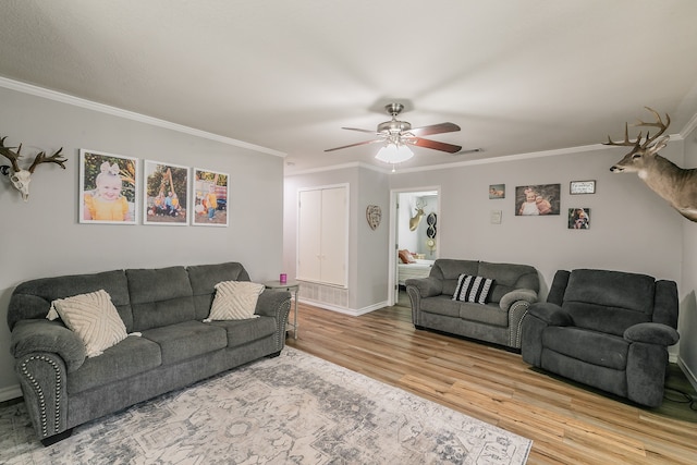 living room with ceiling fan, crown molding, and light hardwood / wood-style floors