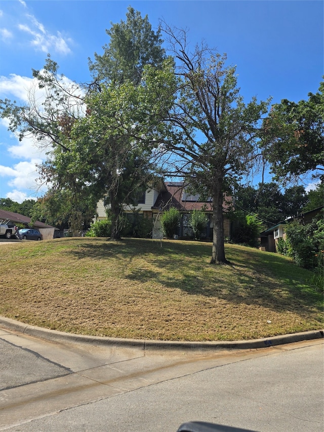 obstructed view of property featuring a front lawn