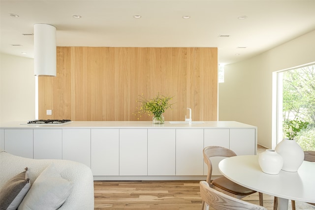 kitchen featuring sink, white cabinetry, stainless steel gas cooktop, and light wood-type flooring