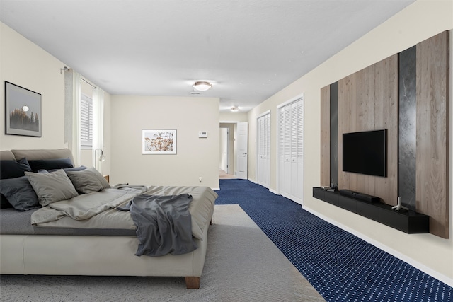 bedroom featuring carpet and two closets