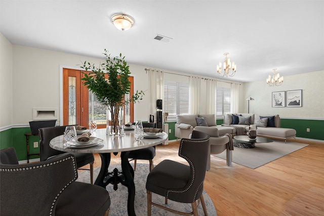 dining room with a notable chandelier and light hardwood / wood-style floors