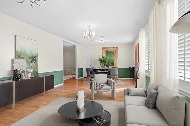 living room featuring a notable chandelier and light hardwood / wood-style floors