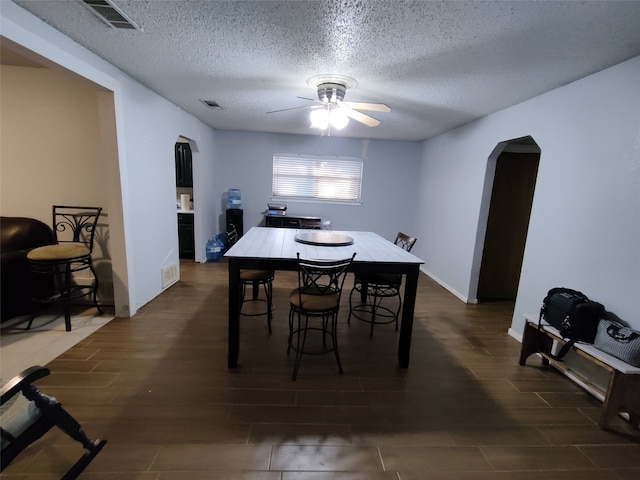 dining area featuring a textured ceiling, dark hardwood / wood-style flooring, and ceiling fan