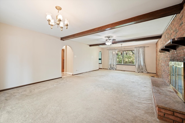 unfurnished living room featuring ceiling fan with notable chandelier, brick wall, light carpet, and a fireplace