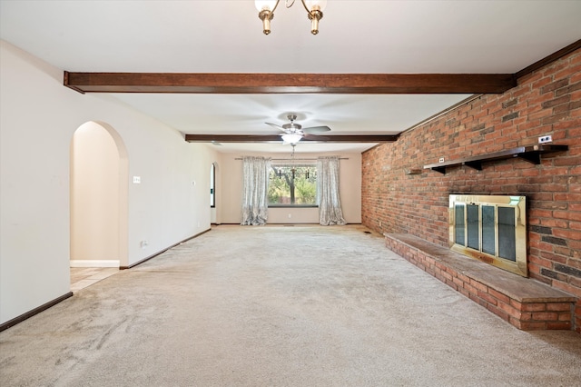 unfurnished living room with a fireplace, brick wall, ceiling fan, and light carpet