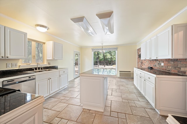 kitchen with a kitchen island, white cabinets, light tile patterned floors, sink, and crown molding