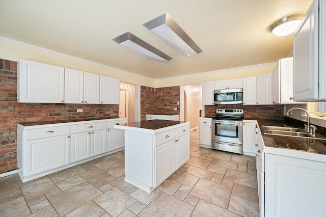 kitchen with light tile patterned flooring, appliances with stainless steel finishes, and white cabinetry