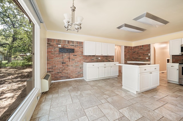 kitchen featuring a notable chandelier, range, light tile patterned floors, hanging light fixtures, and white cabinets