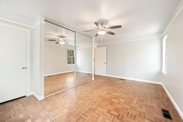 unfurnished bedroom with ceiling fan, light parquet flooring, and ornamental molding