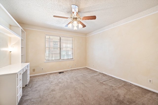 carpeted spare room with a textured ceiling and ceiling fan