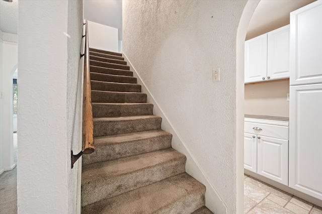 staircase featuring tile patterned floors