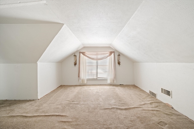 bonus room with a textured ceiling, carpet flooring, and lofted ceiling