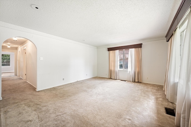 carpeted spare room featuring crown molding and a textured ceiling