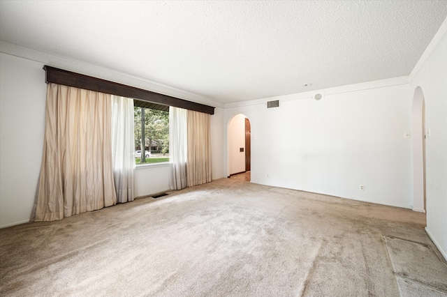 unfurnished room featuring a textured ceiling and light carpet