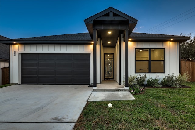 view of front of house featuring a garage and a front lawn