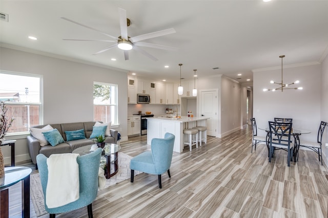 living room with ceiling fan with notable chandelier, crown molding, sink, and light hardwood / wood-style flooring