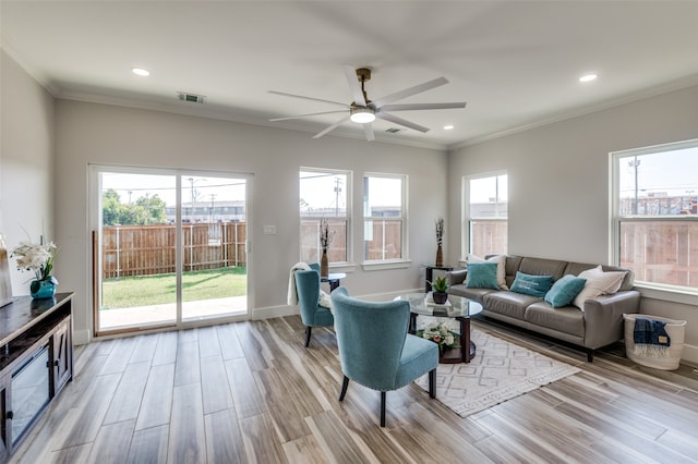 living room with light hardwood / wood-style floors, crown molding, and ceiling fan