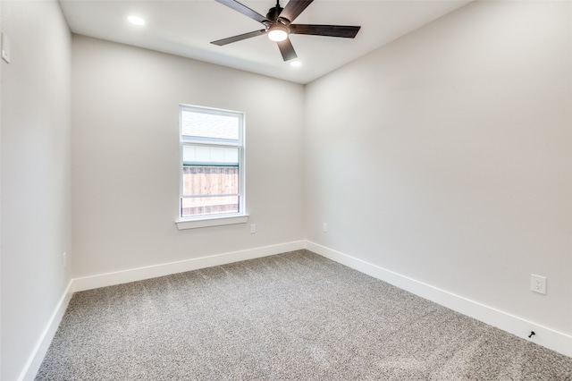 spare room with ceiling fan and carpet