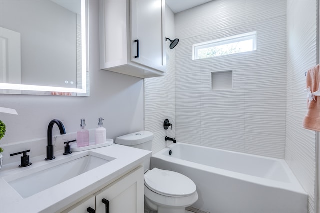 full bathroom featuring vanity, tiled shower / bath combo, and toilet