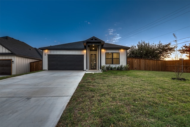 view of front of home with a garage and a yard