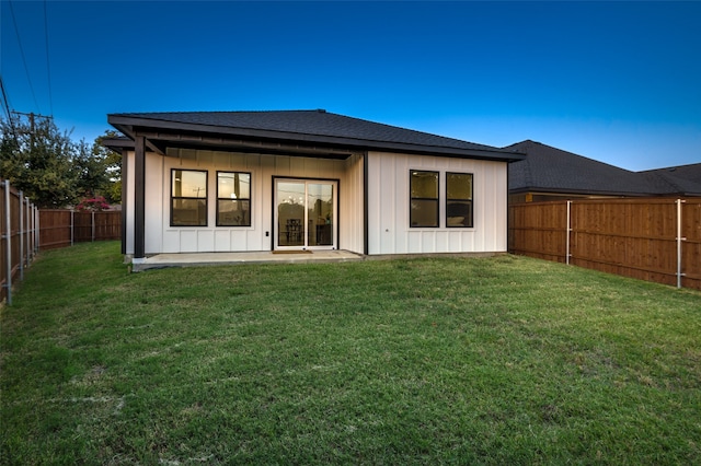 back of property with a lawn and a patio