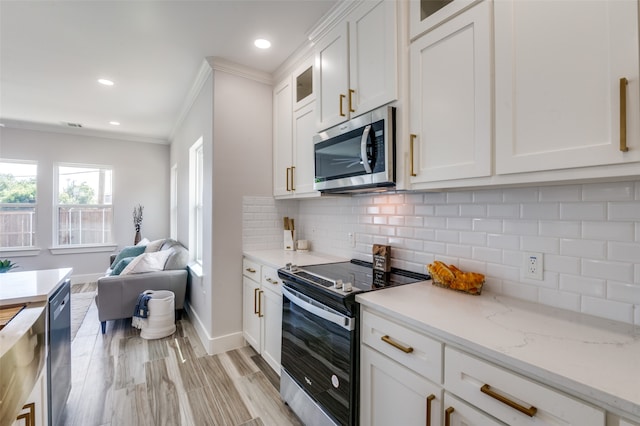 kitchen featuring light stone counters, stainless steel appliances, white cabinetry, ornamental molding, and backsplash