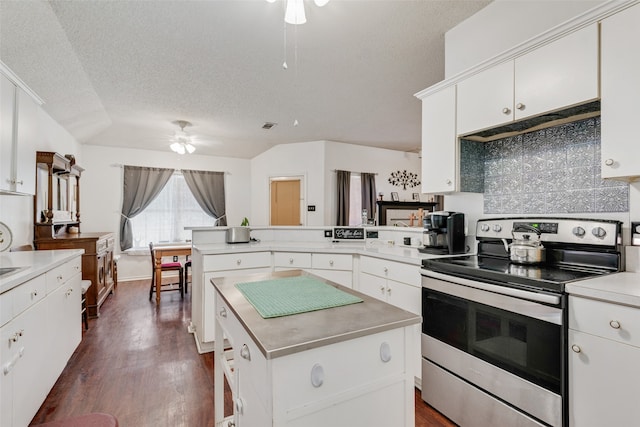 kitchen featuring ceiling fan, decorative backsplash, dark wood-type flooring, stainless steel electric range oven, and white cabinetry