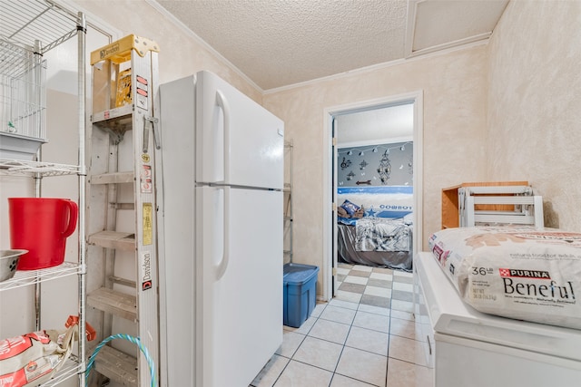 kitchen with a textured ceiling, ornamental molding, white fridge, and light tile patterned floors