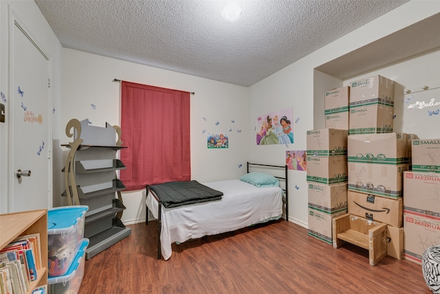 bedroom featuring a textured ceiling and dark wood-type flooring