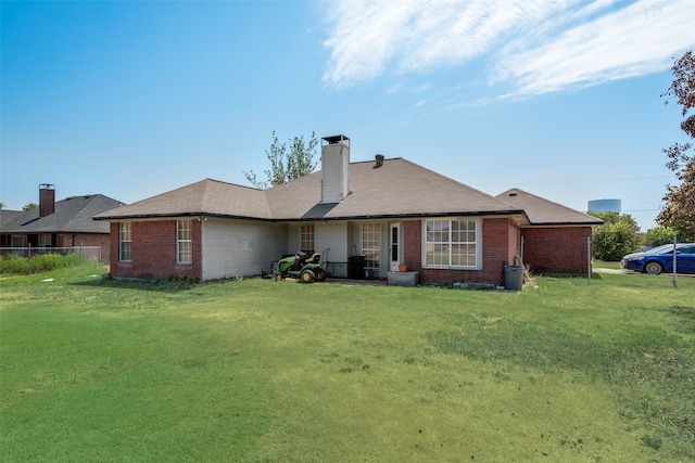 rear view of property with a yard